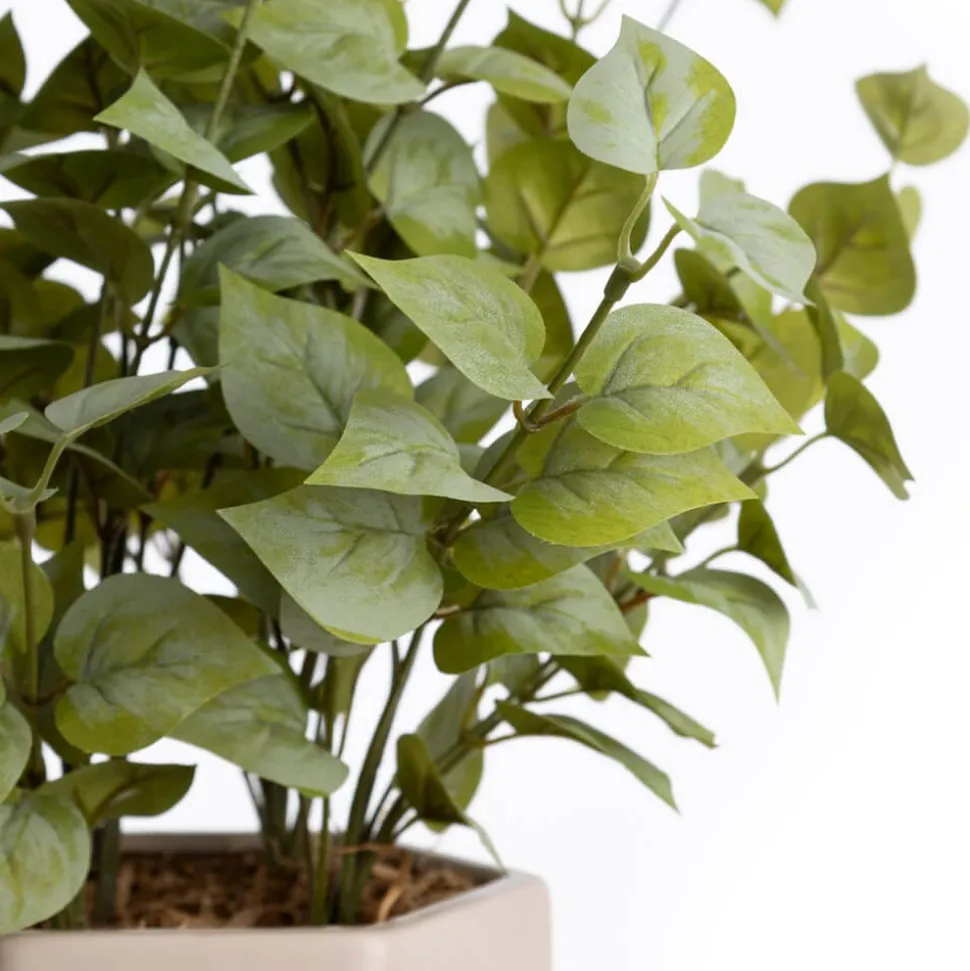 Artificial eucalyptus foliage in a beige vase