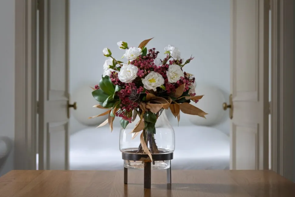 Artificial fall bouquet in a standing glass vase