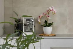 Artificial pink orchid in a white pot