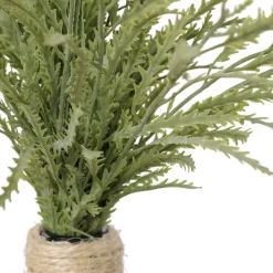 Artificial staghorn fern in a glass vase