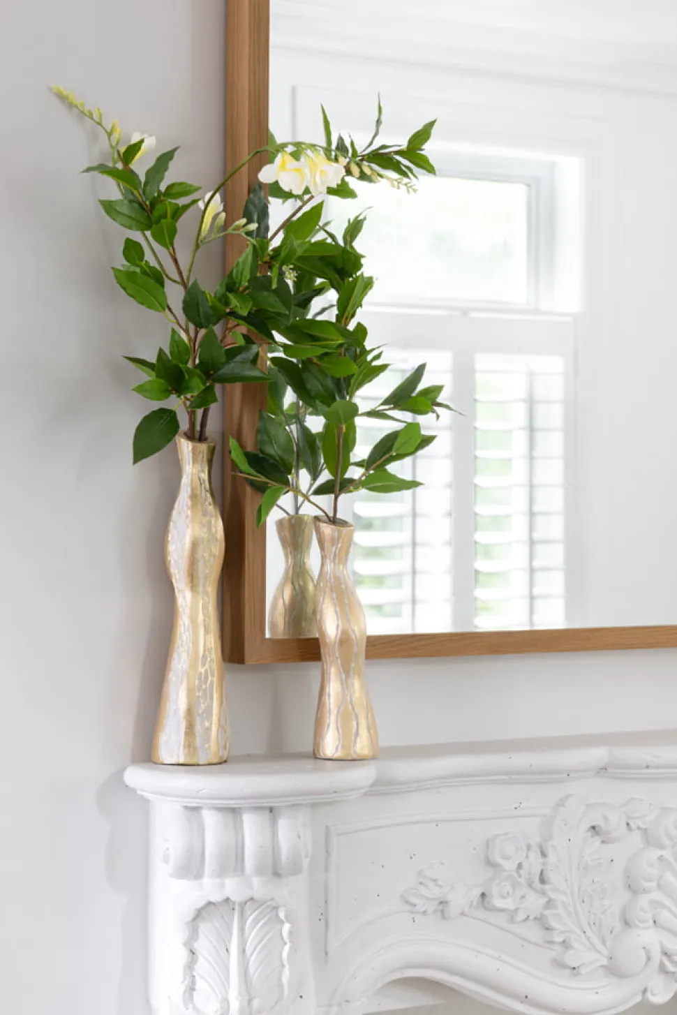 Duo of small tabletop vases with artificial greenery