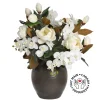 Magnolia and orchid arrangement in a vase