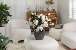 Magnolia and orchid arrangement in a vase