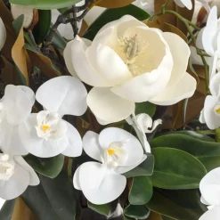 Magnolia and orchid arrangement in a vase